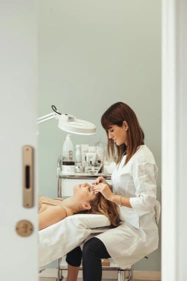 Esthetician working with a client in a treatment room